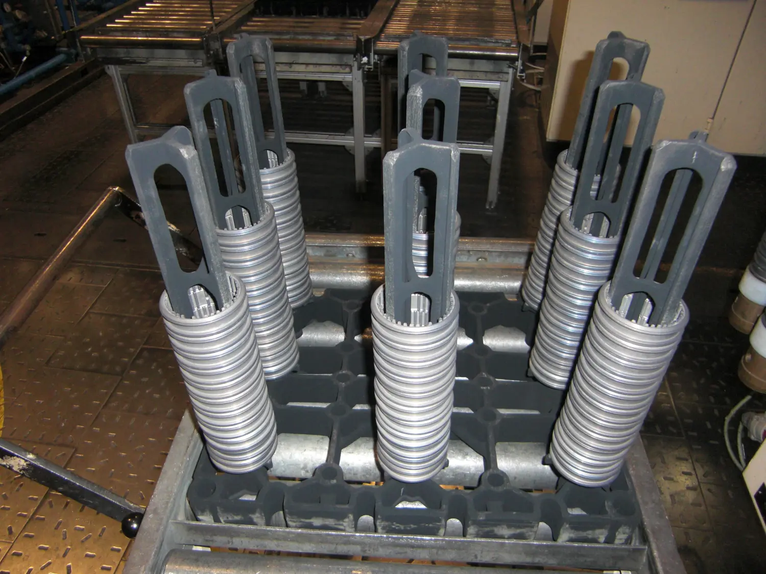 Zeigt Komponenten eines Kugelgewindetriebs oder eines Leitspindelwalzprozesses, möglicherweise Werkstücke oder fertige Schrauben und möglicherweise Teile der Maschinen, die zu ihrer Herstellung verwendet werden.