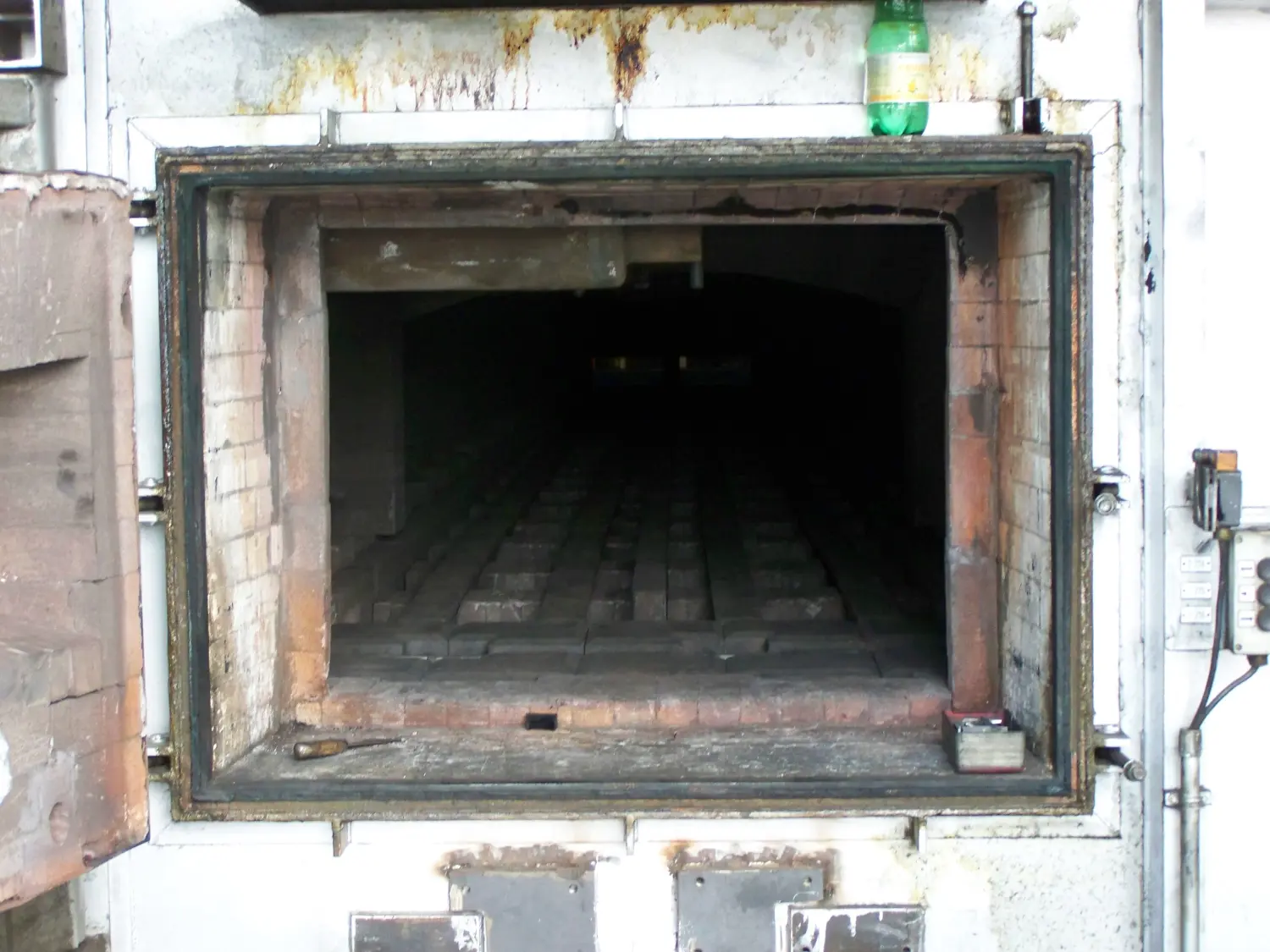 das Innere eines Industrieofens oder -ofens, wahrscheinlich ein Muffelofen oder ein Herdwagenofen, basierend auf seiner Bauart und dem Vorhandensein von feuerfesten Steinen. von Härterei Service Dirk Gieselmann